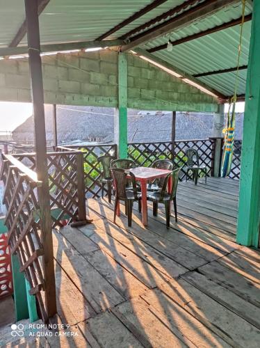 a table and chairs on a wooden deck at Barra Zacapulco - Palapa Abraham 