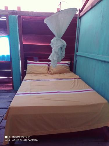 a bed in a room with an umbrella on it at Barra Zacapulco - Palapa Abraham 