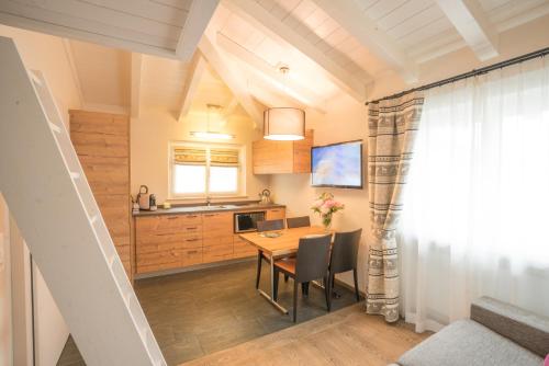 a kitchen and dining room with a table and chairs at Hotel La Romantica in Le Prese, Poschiavo