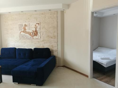 a living room with a blue couch and a bed at Apartament DINO in Ustka