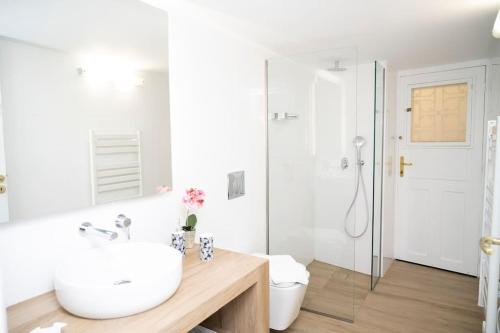 a white bathroom with a sink and a toilet at HomeResidence 1 in Ermoupoli
