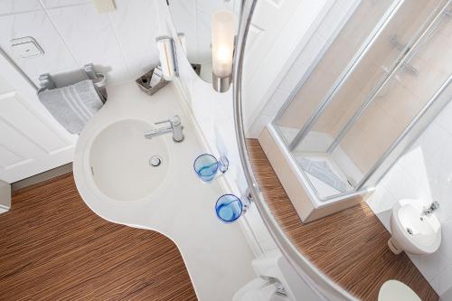 ein Badezimmer mit einem WC mit blauer Brille darauf in der Unterkunft Hotel Schlösschen Sundische Wiese Zingst in Zingst