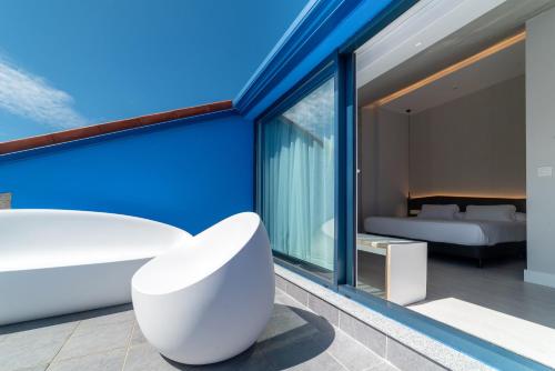 ムシアにあるA de Loló Alojamiento con encantoの白い椅子とベッドが備わる客室です。