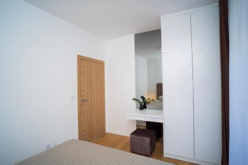 a bedroom with a bed and a white cabinet at Riverland - luxury apartment Mostar in Mostar