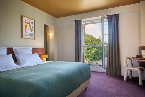a hotel room with a large bed and a window at Maison du Val - Les Maisons de Campagne in Saint-Germain-en-Laye