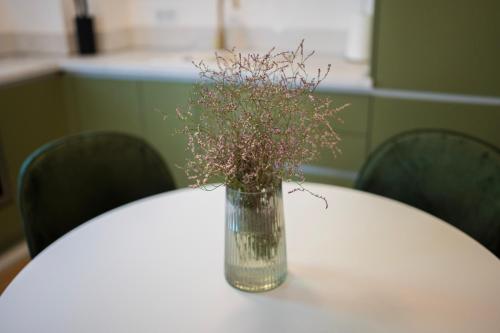 a vase of flowers sitting on a table at Riverland - luxury apartment Mostar in Mostar