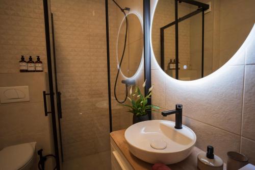 a bathroom with a sink and a shower with a mirror at Riverland - luxury apartment Mostar in Mostar