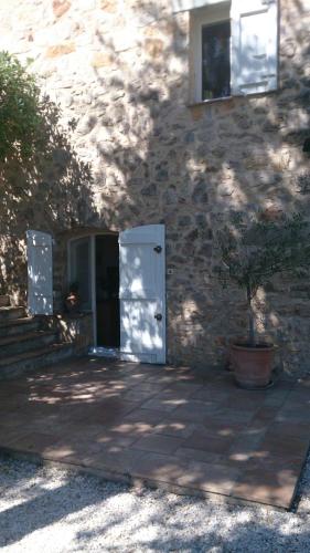 a building with a door and a tree in front of it at Le Clos sous le chemin in Seillans