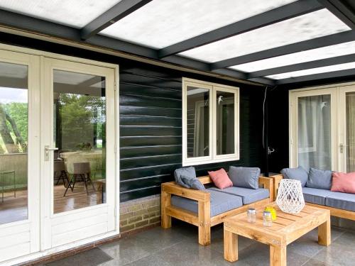 a patio with two couches and a table at Idyllic house with 360 view of nature in Dalfsen