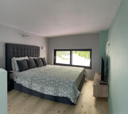 een slaapkamer met een groot bed en een raam bij John's Minimal Loft in Agios Nikolaos