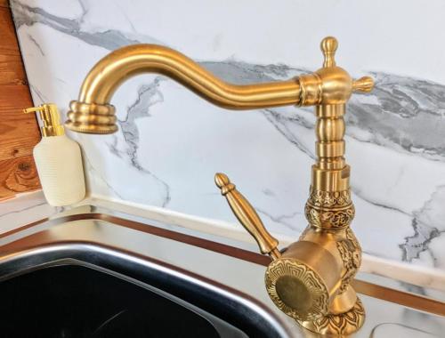 a gold faucet over a sink in a bathroom at Kaoglen Apollo-Hot tub-Cairngorms-Pet friendly in Balnald