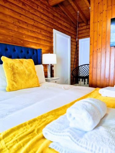 a bedroom with a large white bed with a blue headboard at Kaoglen Apollo-Hot tub-Cairngorms-Pet friendly in Balnald