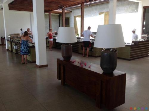 um grupo de pessoas em pé numa sala com duas lâmpadas em Suriya Resort em Wayikkal