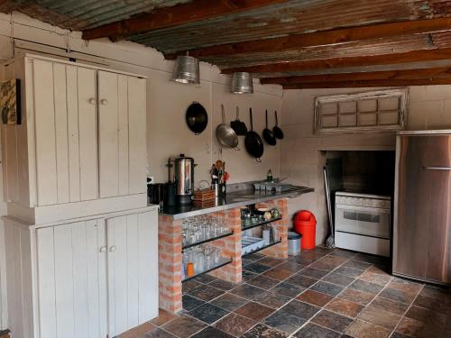 a kitchen with white cabinets and a brick counter at River Kaya in Kromriviermond