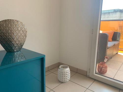 een kamer met een blauwe kast en een vaas op een vloer bij Bel appartement neuf climatisé & parking in Perpignan