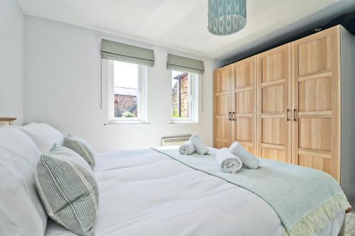 a bedroom with a large white bed with towels on it at Peaceful, rural cottage on the outskirts of Padstow in Padstow