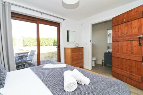 a bedroom with a bed with two towels on it at Peaceful, rural cottage on the outskirts of Padstow in Padstow