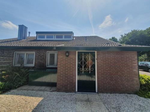 a brick house with a front door with a window at 't Schoenmakershuisje in Epen