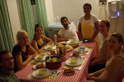 a group of people sitting around a table eating food at Jojies Homestay Fortkochi in Cochin