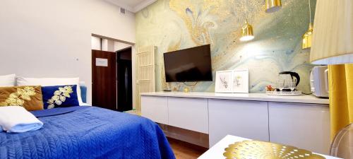 a bedroom with a blue bed and a tv at VIP Apartamenty Stara Polana 2 in Zakopane