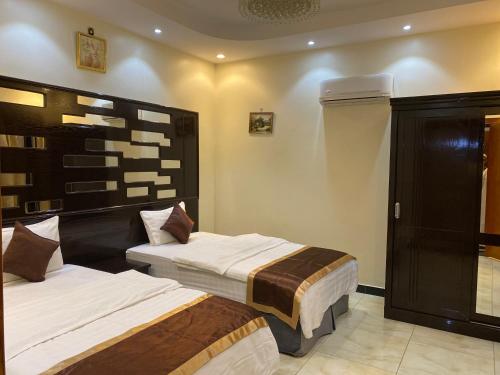 two beds in a hotel room with at ABHASKY in Abha