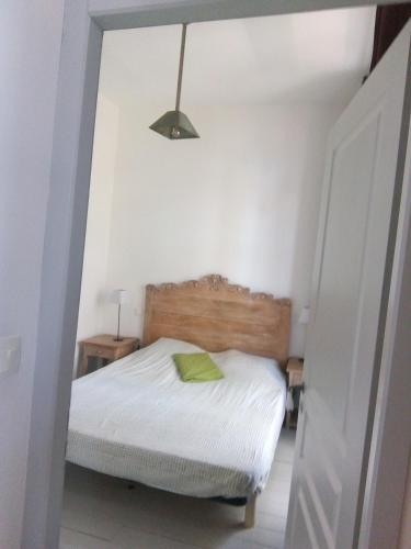 Un dormitorio con una cama con una almohada verde. en VUE SUR VIGNES en Olonzac
