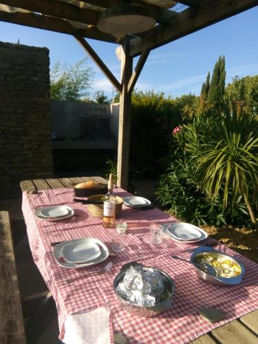 una mesa de picnic con platos de comida y una botella de vino en VUE SUR VIGNES en Olonzac
