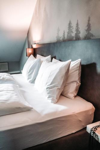 a bedroom with a bed with white pillows at The HEY HOTEL in Interlaken