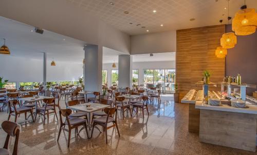 a restaurant with tables and chairs in a room at Toxotis Hotel in Protaras