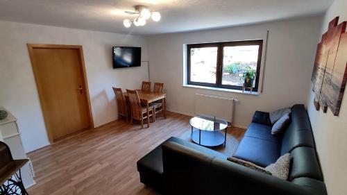 a living room with a couch and a table at *Gemütliche Ferienwohnung in perfekter Lage* in Wilsdruff