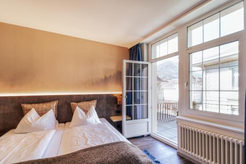a bedroom with a bed and a large window at The HEY HOTEL in Interlaken