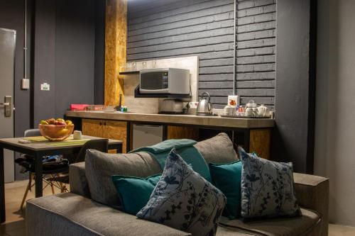 a kitchen with a couch and a table with a microwave at Lilian Lofts Hotel & Spa in Johannesburg