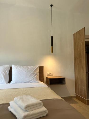 a bedroom with a bed with towels on it at angels apartments in Parga