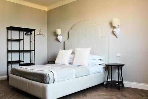 a bedroom with a large white bed with two tables at Mori e Pupe Guest House in Taranto