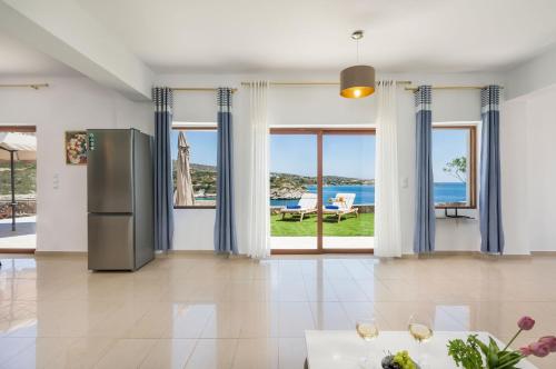 a kitchen with a refrigerator and a view of the ocean at Cap Bleu Seafront Holiday Home in Marathi