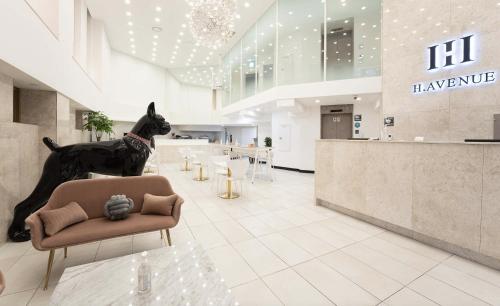 a dog standing on a chair in a lobby at H Avenue Hotel Idae Shinchon in Seoul