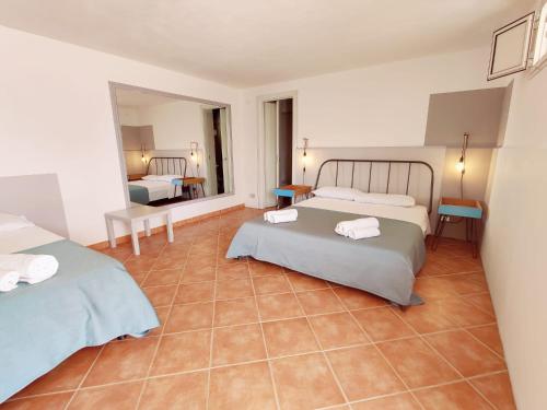 a bedroom with two beds and a tile floor at Villa Talìa in Marsala