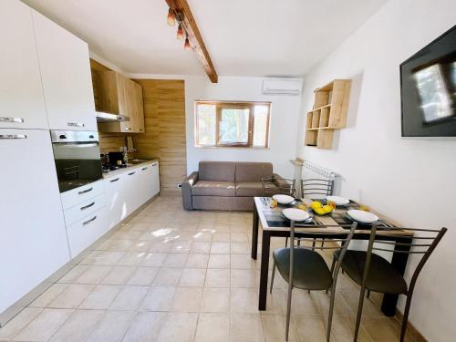 a kitchen and a living room with a table and chairs at Profumo di Limoni Vacation Rental in Procida
