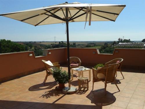 a patio with a table and an umbrella at Casa Vacanze Giulienso in Ardea