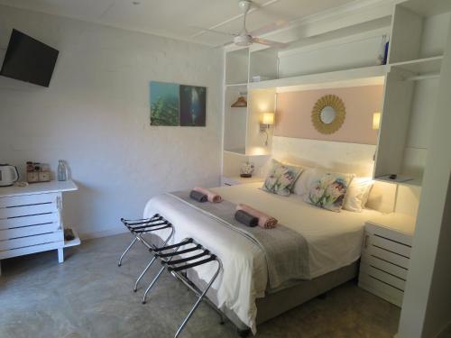 a bedroom with a bed and two chairs in it at Bare Feet Retreat in Scottburgh