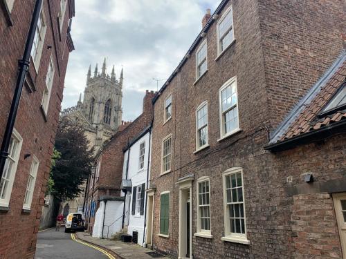 an alley with brick buildings and a cathedral at 7 Precentor's Court in York
