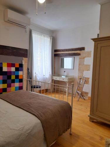 une chambre avec un lit et un bureau dans une pièce dans l'établissement Manoir Demouret Sarlat, à Sarlat-la-Canéda