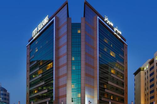 Un palazzo alto con un cartello sopra di City Seasons Suites a Dubai
