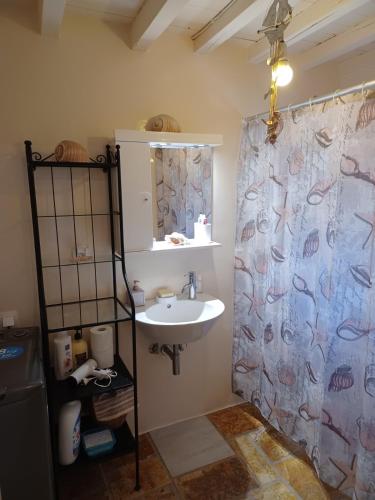 a bathroom with a sink and a shower curtain at Relax house in Kanakis