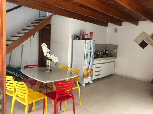 una cucina con tavolo, sedie e frigorifero di Chalé Paraíso Corumbau - Chalés Uvas Azul a Corumbau