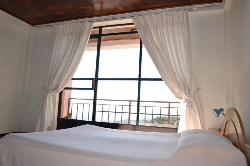a bedroom with a bed and a large window at Jerusalem Hotel Lalibela in Lalibela