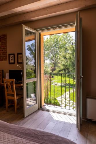 an open sliding glass door with a view of a yard at Agriturismo Cascina Pezzolo in Lodi