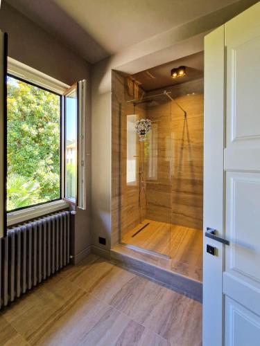 a bathroom with a shower with a glass door at Villa Sarchi in Grantola