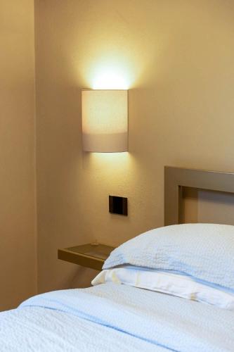 a bedroom with a bed and a light on the wall at Villa Sarchi in Grantola