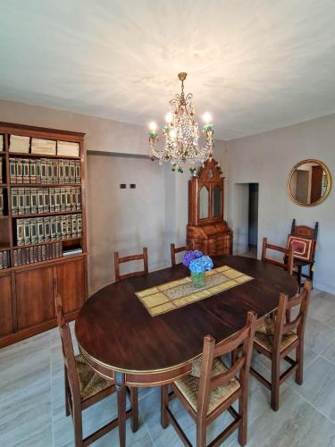 a dining room with a wooden table and a chandelier at Villa Sarchi in Grantola